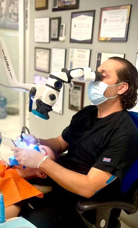 Fotografía de atención con microscopio y clínica de Endodoncia, extraída del folleto COES 2026